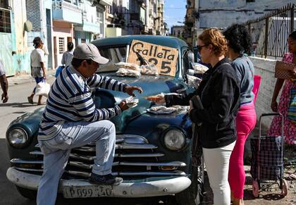 Un hombre vende galletas en su auto en La Habana, en diciembre de 2023