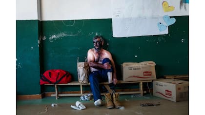 Un hombre se saca las medias después de actuar como un Zarramaco un personaje que mancha su cara en negro y suena cencerros