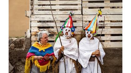 Una mujer habla con un par de jóvenes vestidos como Zarramaches un personaje del tradicional carnaval de Casavieja