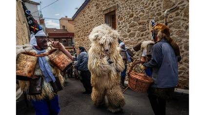 Un hombre que representa a un oso salvaje corre a través de Zarramacos sonando sus cencerros en el carnaval tradicional de La Vijanera de Silio