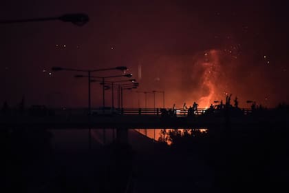 Un incendio bordea una autopista cercana a Atenas (Photo by LOUISA GOULIAMAKI / AFP)