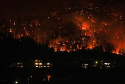 Un incendio forestal arde en las montañas a un costado de West Kelowna, en Columbia Británica, Canadá