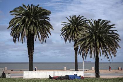 Un indigente duerme en un parque de la Rambla de Montevideo el 6 de septiembre de 2020