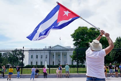 Un individuo hace ondear una bandera de Cuba frente a la Casa Blanca el 13 de julio del 2021 en Washington, durante una pequeña manifestación de apoyo a los cubanos que salieron a la calle a protestar contra el gobierno de la isla. (AP Photo/Susan Walsh)
