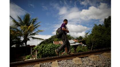 Un inmigrante camina por las vías luego de salir de las instalaciones de Las Patronas