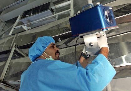 Un inspector de Organismo Internacional de la Energía Atómica coloca equipo de vigilancia en la Instalación Iraní de Conversión de Uranio a las afueras de la ciudad de Isfashan, Irán, el 8 de agosto de 2005. (AP Foto/Mehdi Ghasemi, ISNA, Archivo )