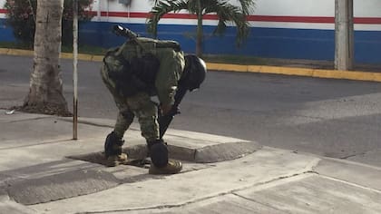 Un integrante de la Marina Armada de México apunta con su arma hacia adentro de una alcantarilla hoy, viernes 8 de enero de 2016 en la ciudad de Los Mochis, estado de Sinaloa (México)