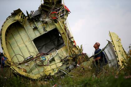 Un investigador estudia un pedazo del avión en Hrabove, en 2014