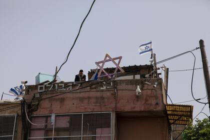 Un israelí ultra-ortodoxo observa desde el techo de una casa en el barrio de Sheikh Jarrah, Jerusalén Este