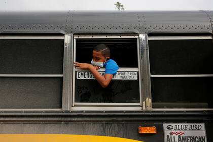 Un joven hondureño que intentaba llegar a Estados Unidos mira por la ventana de un autobús mientras espera volver a casa después de ser enviado de regreso por las autoridades guatemaltecas, en El Florido, Honduras, en la frontera con Guatemala