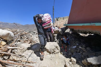 Un joven lleva suministros sanitarios al pueblo destruido de Imoulas en la provincia de Taroudant, una de las más devastadas por el terremoto en Marruecos, el 11 de septiembre de 2023. 