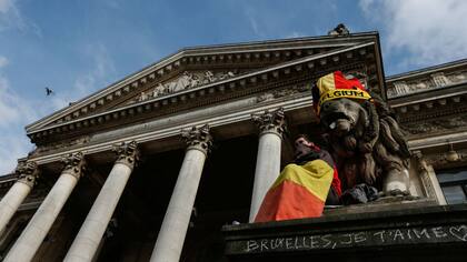 Un joven muestra una bandera belga en el Palacio Bourse, de Bruselas