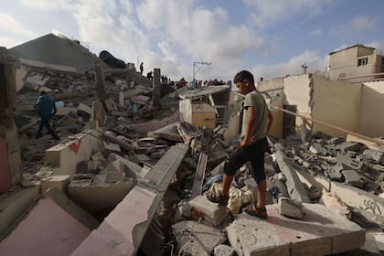 Un joven palestino inspecciona los escombros de un edificio alcanzado por un bombardeo israelí nocturno en Rafah, en el sur de la Franja de Gaza, el 21 de abril de 2024, en medio del conflicto en curso entre Israel y el grupo islamista palestino Hamas.