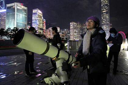 Un joven utiliza un telescopio para ver la superluna en Victoria Harbour, Hong Kong Hong Kong