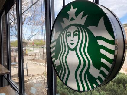 Un letrero con el logotipo de Starbucks en la ventana de una de las cafeterías de la compañía en Denver, el lunes 26 de abril de 2021. (AP Foto/David Zalubowski)