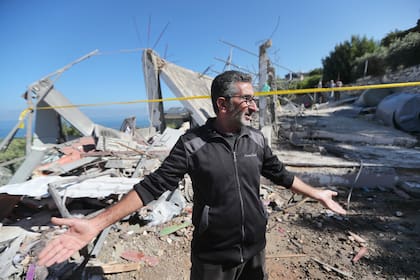 Un libanés gesticula junto a una casa destruida en el poblado sureño de Adloun tras un ataque israelí (Archivo) 