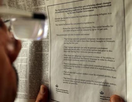 Un libanés mira un anuncio sobre las nuevas y más estrictas restricciones para los solicitantes de asilo en Dinamarca.