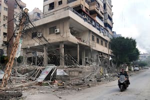 Un libanés pasa en motocicleta junto a un edificio dañado en un ataque israelí, en Dahiyeh, a las afueras de Beirut, Líbano, el 7 de octubre de 2024. (AP Foto/Hussein Malla)