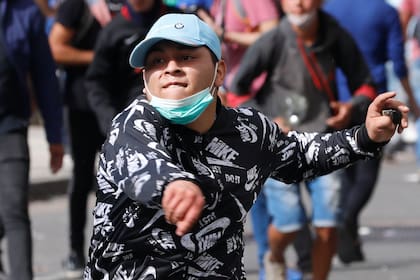 Un manifestante arroja piedras durante los disturbios frente al Congreso Nacional