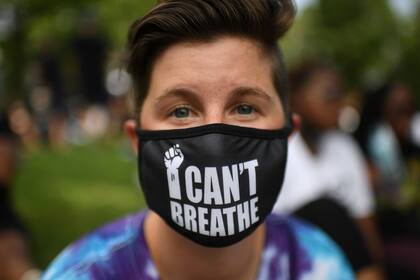 Un manifestante con tapabocas asiste a la protesta "Marcha por el compromiso: quítate la rodilla del cuello" contra el racismo y la brutalidad policial el 28 de agosto de 2020 en Washington DC