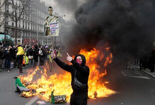 Un manifestante con un poster de Macron en París