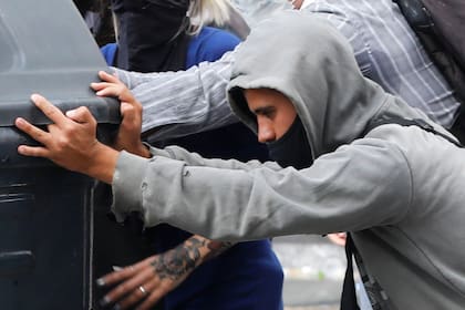 Un manifestante corre un contenedor en los alrededores de la Plaza del Congreso