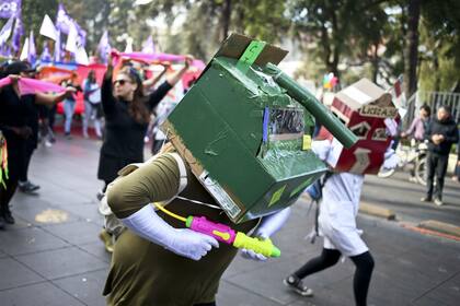 Un manifestante en Santiago, Chile, se burla de los camiones hidrantes