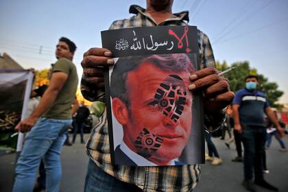Un manifestante iraquí lleva un cartel del presidente francés Emmanuel Macron en una protesta frente a la embajada francesa en Bagdad el 26 de octubre de 2020