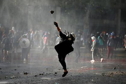 Un manifestante lanza un proyectil durante las protestas en Chile