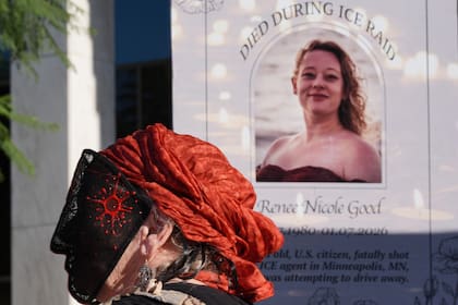 Un manifestante lleva una mascarilla frente a una imagen de Renee Good durante una protesta