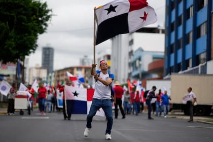 Un manifestante ondea una bandera panameña durante una protesta contra un contrato minero entre el Estado panameño y la compañía minera canadiense First Quantum