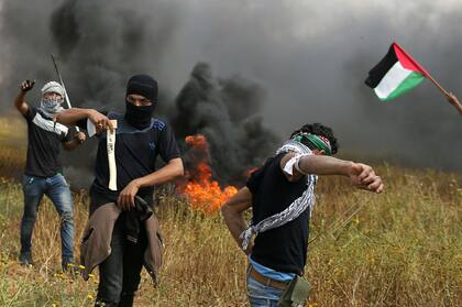 Un manifestante palestino sostiene un hacha durante los enfrentamientos con las tropas israelíes