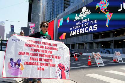 Un manifestante sostiene un cartel a favor de la reforma migratoria frente a la sede de la Cumbre de las América