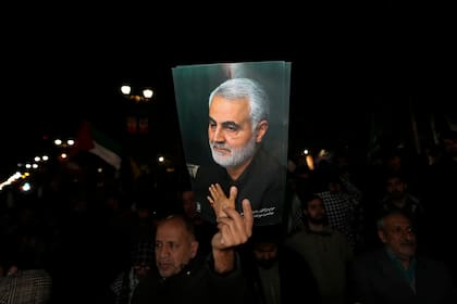 Un manifestante sostiene un cartel del fallecido general de la Guardia Revolucionaria iraní Qassem Soleimani, asesinado en un ataque de dron estadounidense en 2020 en Irak, en un acto contra Israel ante la embajada británica en Teherán, Irán, la madruga del domingo 14 de abril de 2024