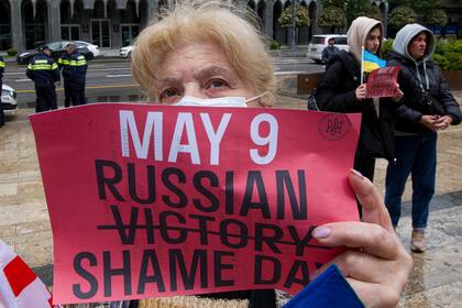 Un manifestante sostiene un cartel durante una protesta antibélica contra la invasión rusa de Ucrania en Tiflis, Georgia, el domingo 8 de mayo de 2022, un día antes de que Rusia celebre el Día de la Victoria, que marca los 77 años de la victoria en la Segunda Guerra Mundial.