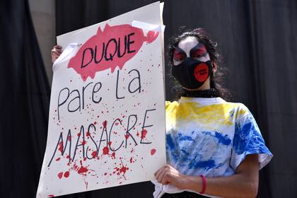 Un manifestante sostiene un cartel con la leyenda "Duque, pare la masacre", durante la huelga nacional contra el Gobierno realizada a comienzos de mayo en Bogotá
