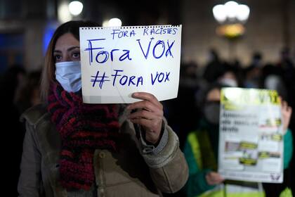 Un manifestante sostiene un cartel que dice "¡Fuera Vox!" durante una protesta convocada por Unidad Contra el Fascismo y el Racismo (UCFR)