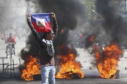 Un manifestante sostiene una bandera haitiana durante las protestas que exigen la renuncia del primer ministro Ariel Henry en Puerto Príncipe, Haití, el viernes 1 de marzo de 2024.