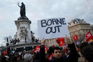 Un manifestante sostiene una pancarta contra la primera ministra francesa, Elisabeth Borne, en la Plaza de la República durante una manifestación, pocos días después de que el gobierno impulsara una reforma de las pensiones a través del parlamento sin votación, utilizando el artículo 49.3 de la Constitución, en París el 21 de marzo de 2023.