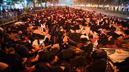Los deudos descansan mientras esperan la procesión fúnebre del fallecido rey tailandés Bhumibol Adulyadej que tendrá lugar en las afueras del Gran Palacio de Bangkok