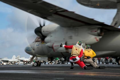 Un marinero vestido como Santa Claus dirige el lanzamiento de un E-2D Hawkeye en la cubierta de vuelo del portaaviones USS Abraham Lincoln.