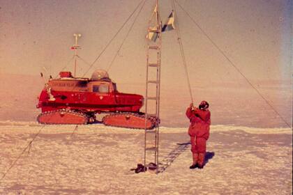 Un mástil en los confines. En diciembre de 1965, un miembro de la primera expedición terrestre argentina al polo sur iza la bandera en el límite austral del país