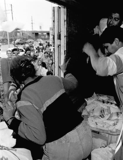 Los empleados del supermercado Llaneza, a tres cuadras de la estación Don Bosco, en Wilde, reparte sachets de leche para evitar los saqueos
