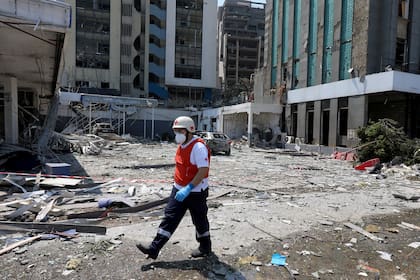 Un miembro de la Cruz Roja recorre una zona destruida por la explosión de ayer, en Beirut, Líbano