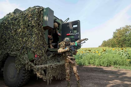 Un miembro de la Guardia Nacional Ucraniana de la 3ra brigada «Spartan» salta de un vehículo blindado durante un entrenamiento cerca del frente en dirección a Pokrovsk, Ucrania, el viernes 8 de agosto de 2025. (AP Foto/Evgeniy Maloletka)