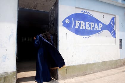 Un miembro de la Iglesia Evangélica Cristiana Misión Israelita del Nuevo Pacto Universal observa una ceremonia de adoración desde la entrada de una de las instalaciones del vecindario de la iglesia que muestra un símbolo de su partido político