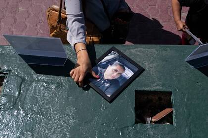 Un miembro de la prensa agarra un retrato de la periodista asesinada Yessenia Mollinedo, quien fue asesinada a primera hora del día, durante una manifestación en el marco del Encuentro Nacional Contra el Asesinato de Periodistas, en Tijuana, Estado de Baja California, México, el 9 de mayo de 2022.
