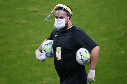 Un miembro del personal del torneo brasileño con una máscara protectora, luego de la reanudación del juego a puerta cerrada después del brote de la enfermedad por coronavirus