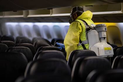 Un miembro del personal del aeropuerto Charles de Gaulle nebuliza el interior de un avión de Air France como parte de un proceso de desinfección del avión,