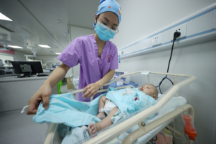 Un miembro del personal médico atiende a un bebé en un hospital al suroeste de China